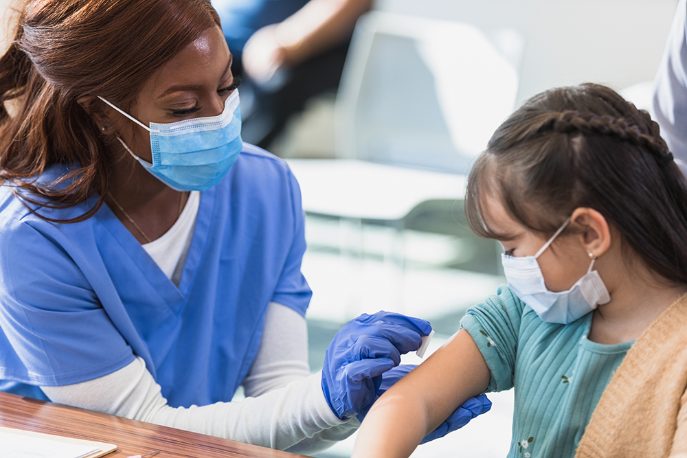 nurse giving shot to young girl