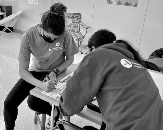 Two volunteers filling out paperwork