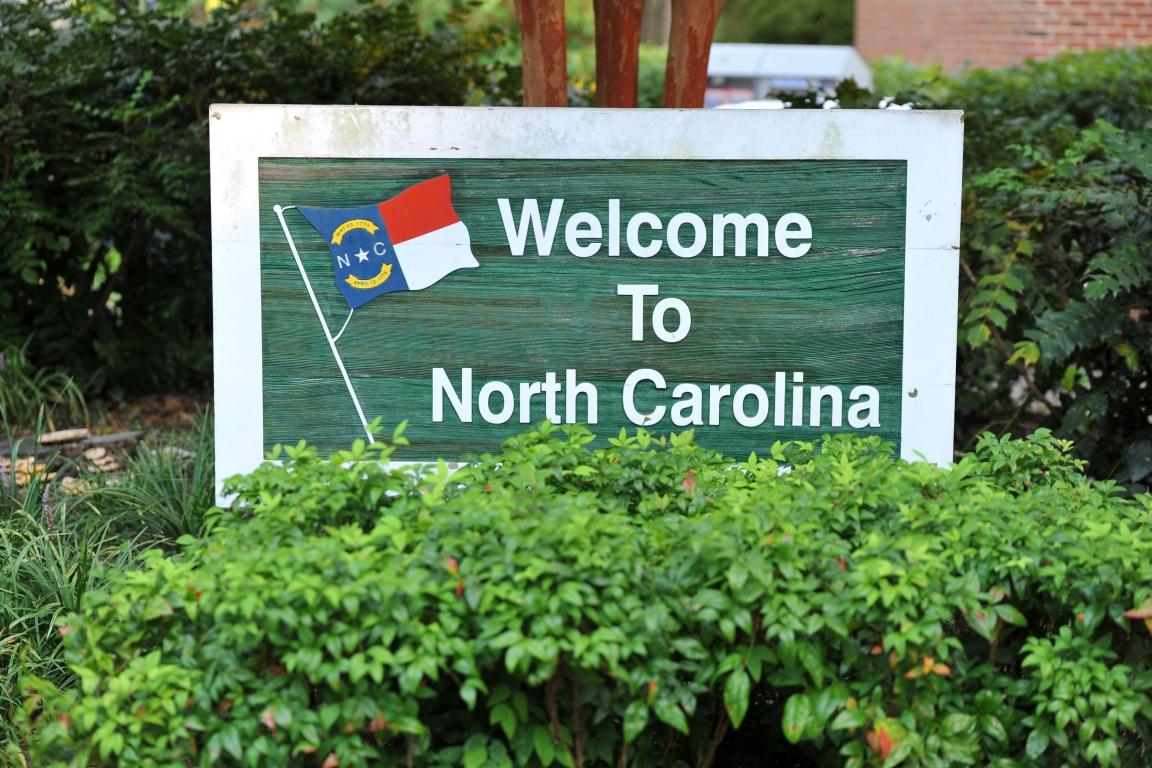 Welcome to North Carolina sign between bushes