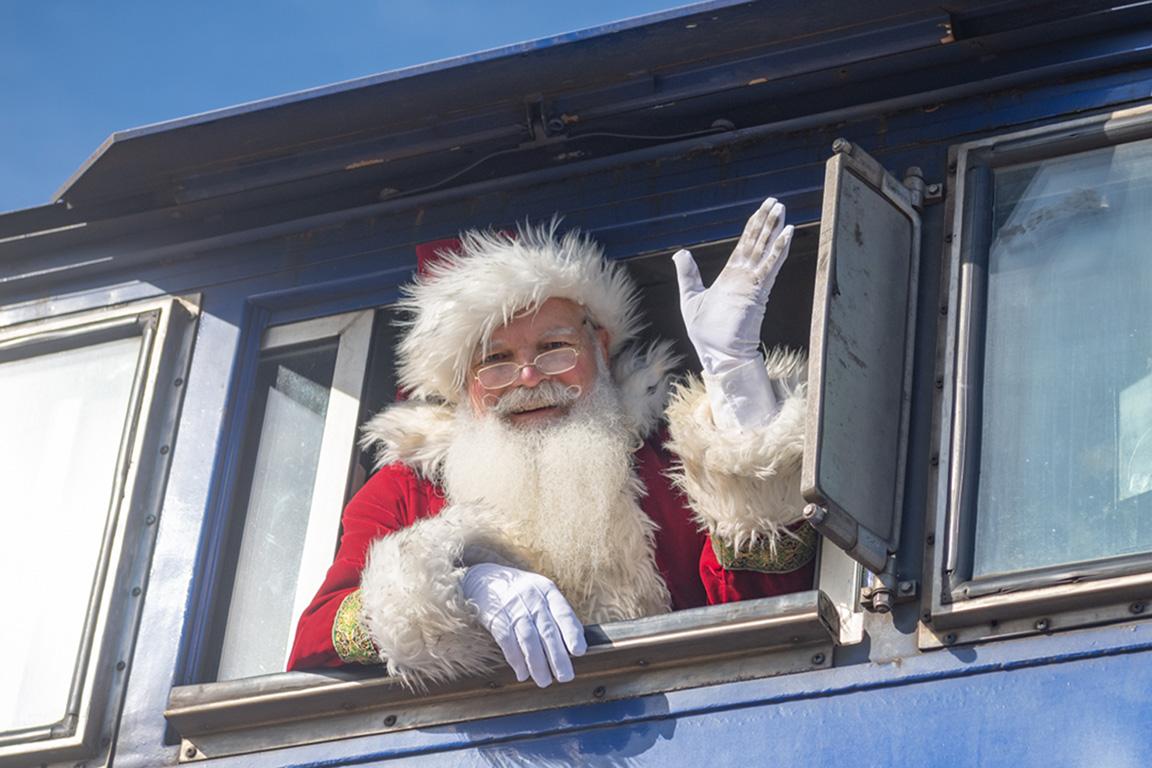 Santa waves hello while riding aboard NC By Train. 