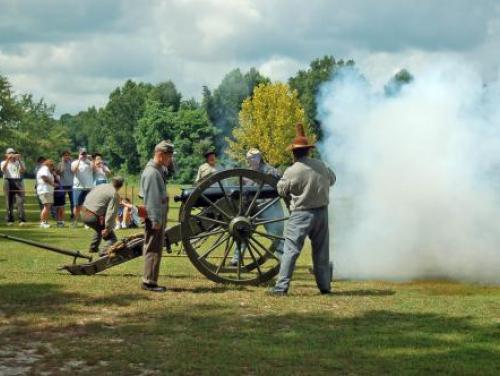 Visitors watch a cannon blast at Bentonville Battlefield