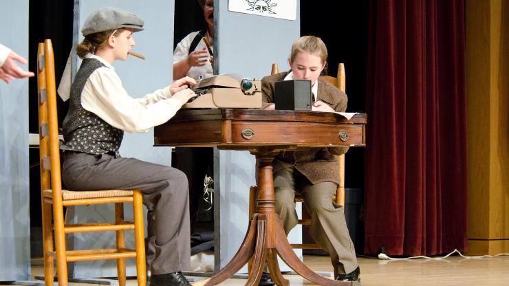 Two National History Day Performance Students Sit at a Table wearing 1930s style costumes.