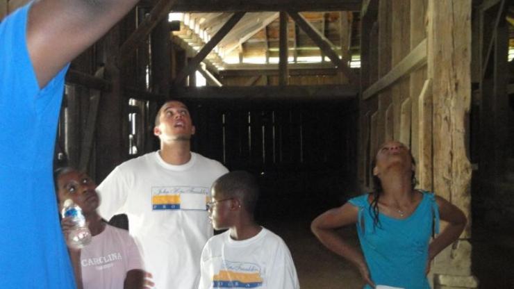 A tour group learns about the Great Barn at Historic Stagville