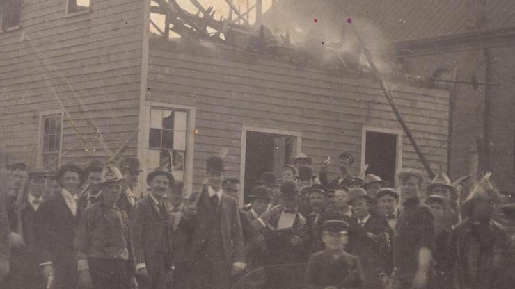 A mob stands at the ruins of Alex Manly's Daily Record office, destroyed November 10, 1898.