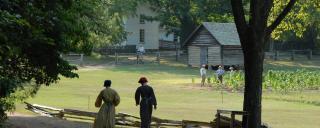 Interpreters Walk Along a Dirt Road at Durham's Duke Homestead
