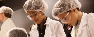 Two young boys at the STEM Career Showcase two young boys in a lab coast and lab goggles