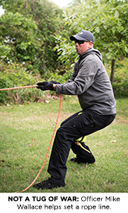 Officer Mike Wallace helps set a rope line