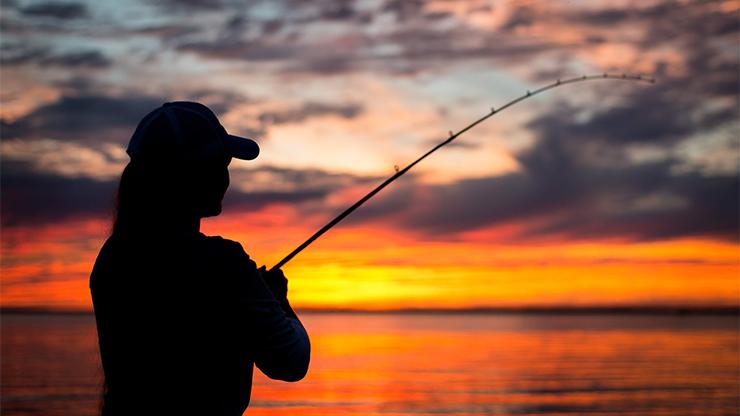 Coastal Angling Program silhouette of a woman fishing at sunset