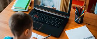 child sitting at desk with computer