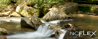 Photo of rushing water falling over rocks in a creek