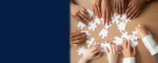 Photo of hands of diverse group around a table assembling puzzle