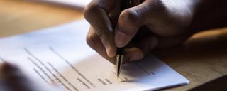 Person filling out a form Person's hand filling out a form
