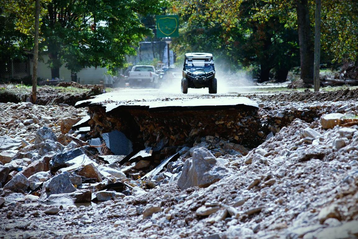 A washed out road, a ATV approaches the washout