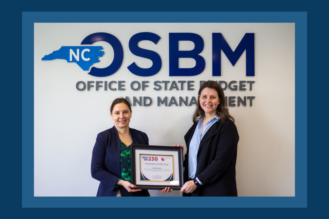 Anca Grozav accepting award certificate from Budget Director Kristin Walker