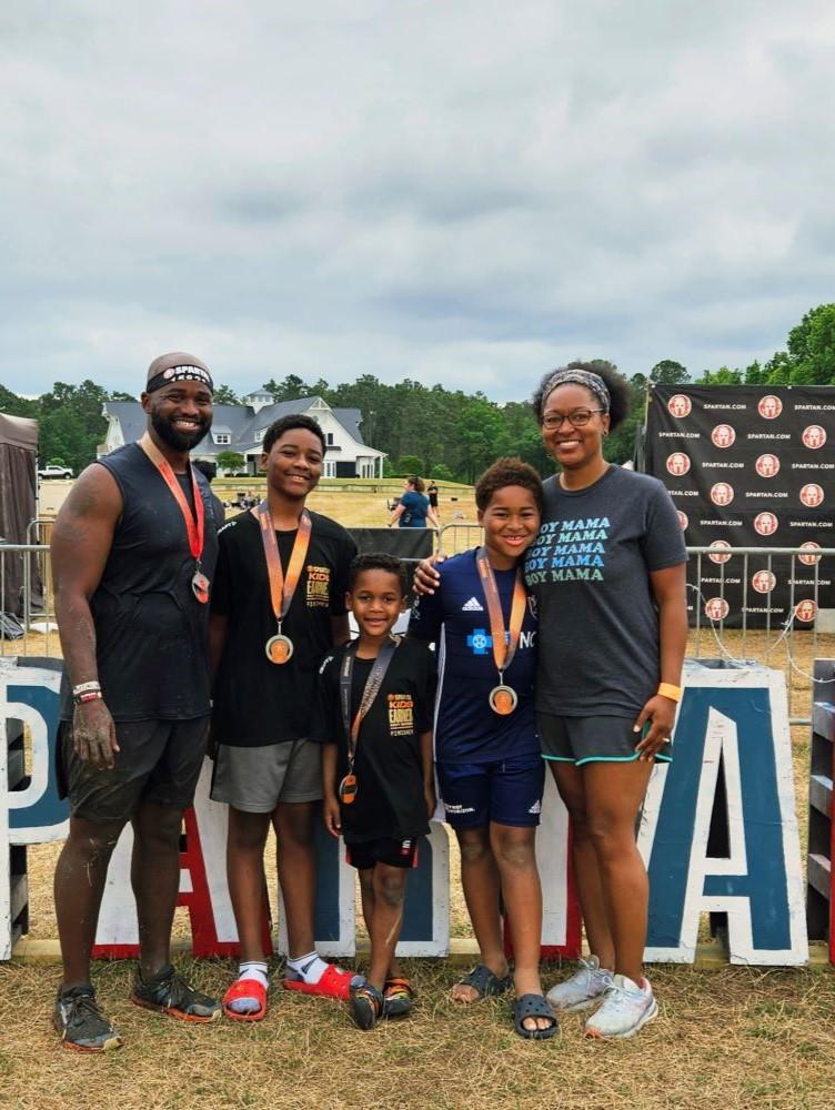 Family in athletic clothes, wearing medals and smiling 
