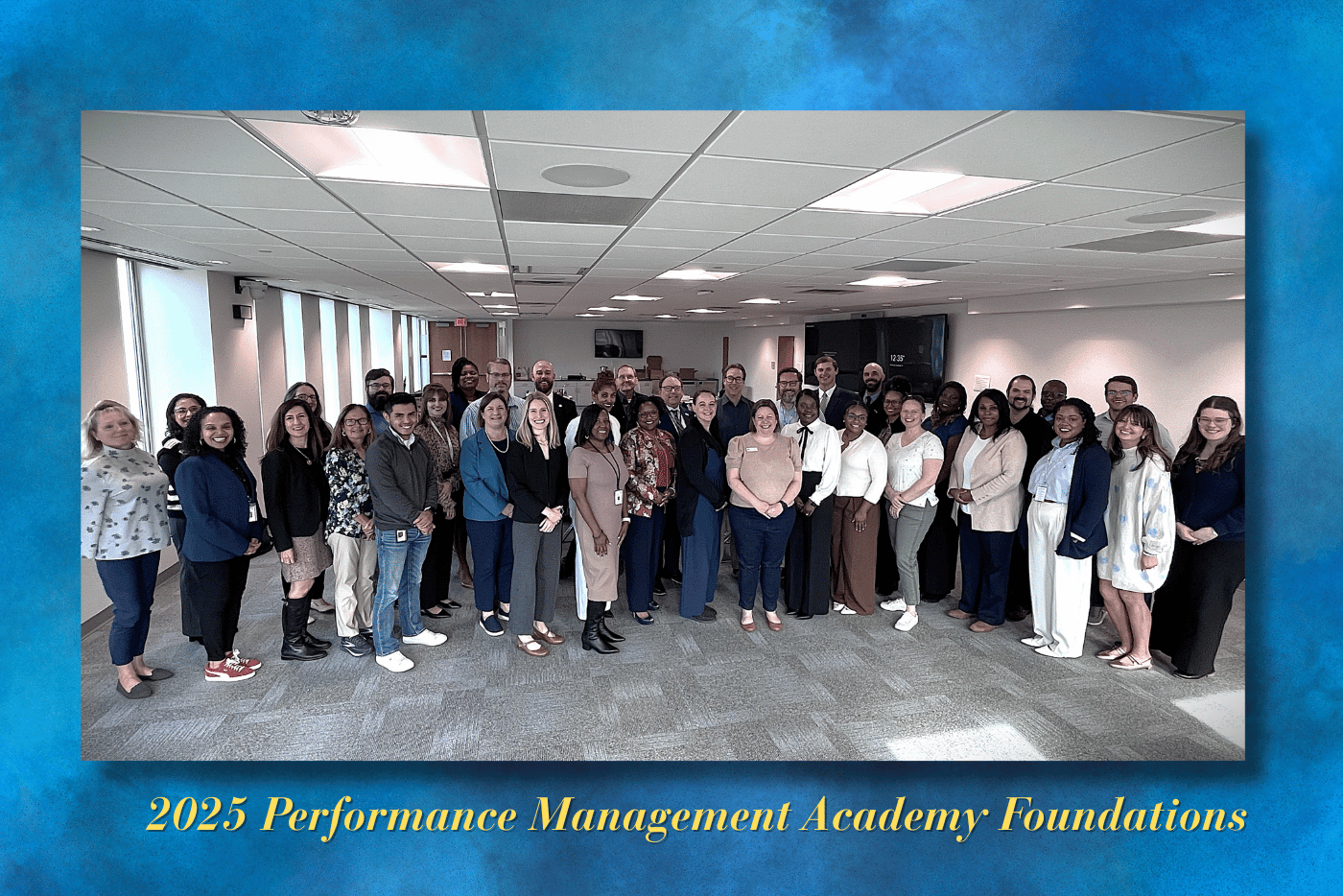 large group of people standing in a semicircle smiling