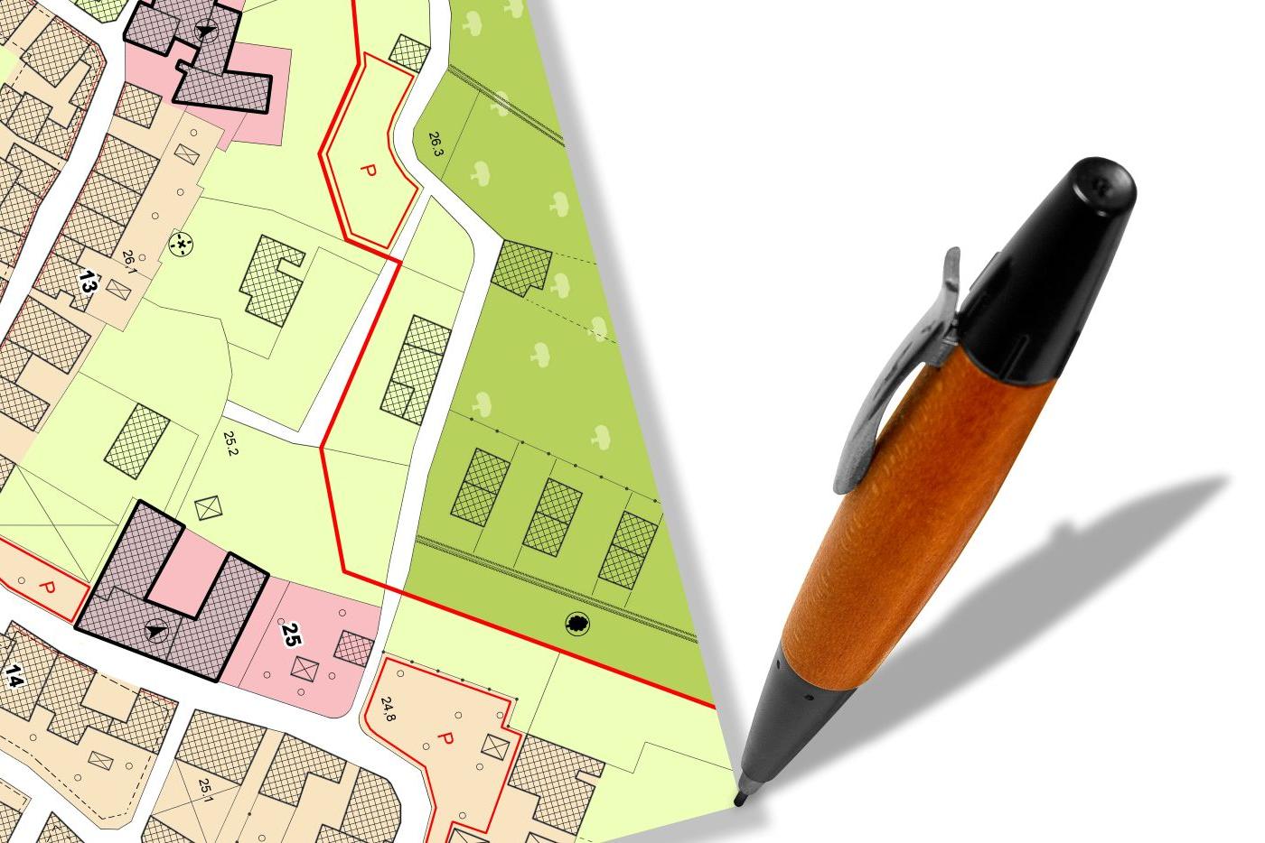 Pen poised by a plat map