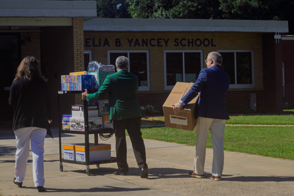 people carrying school supplies into school
