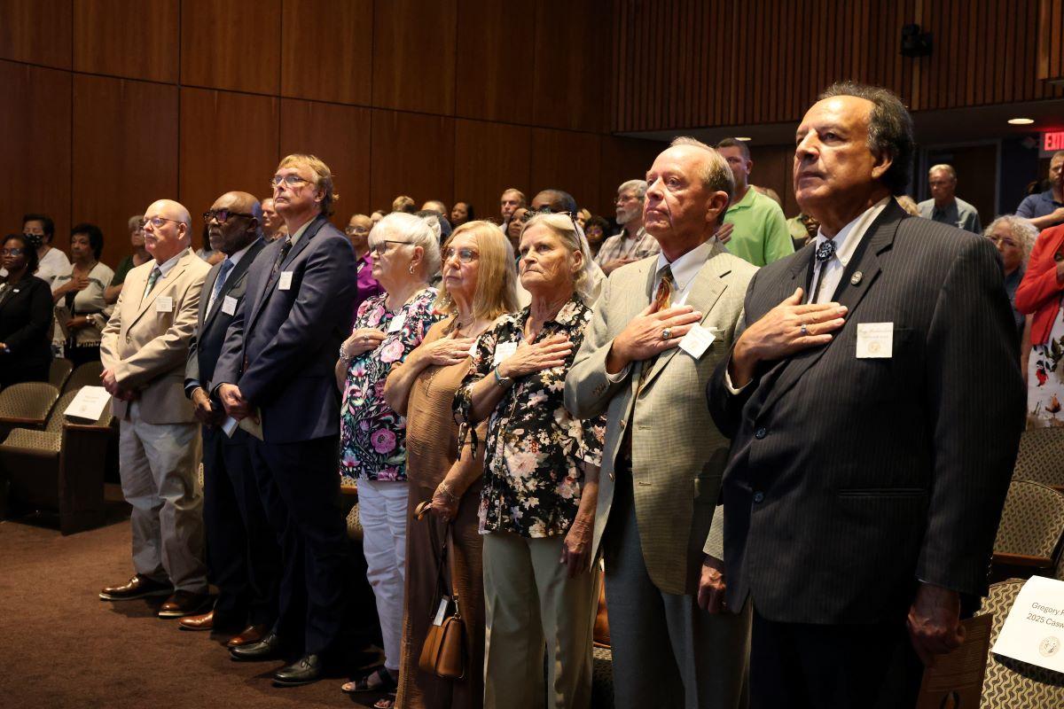 2025 Caswell Award recipients stand for the national anthem at the award ceremony.
