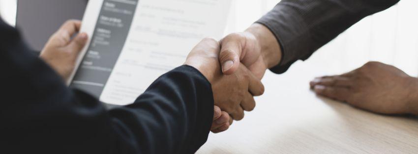 Closeup on a handshake over a desk.