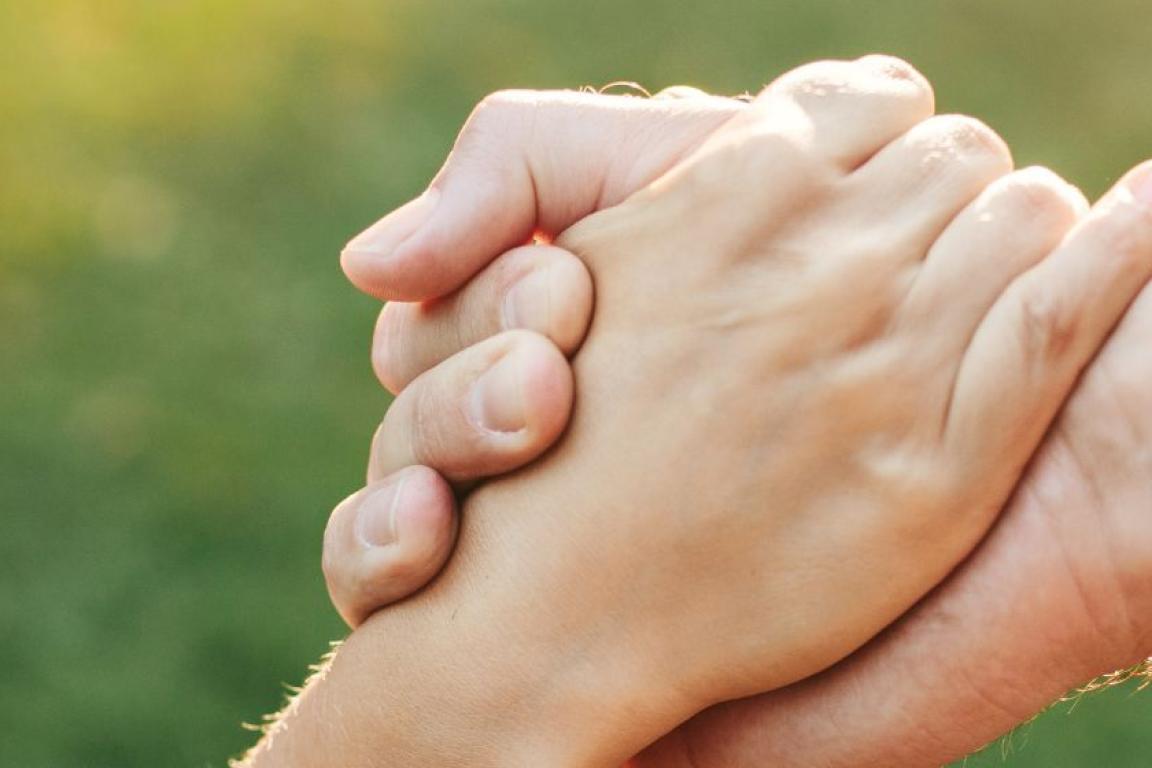 Smiling woman grasps helping hand.