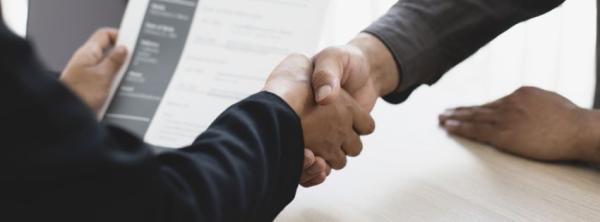 Closeup on a handshake over a desk.