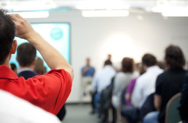 Person in classroom raising hand.