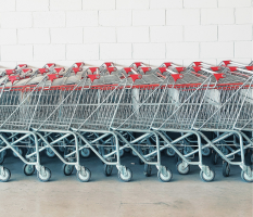 grocery carts lined up in front of a white brick wall