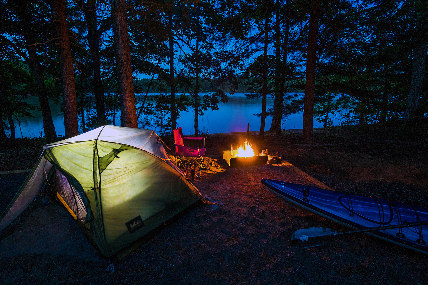 Paddle campsite set up at night, with a lit campfire, at Lake James State Park