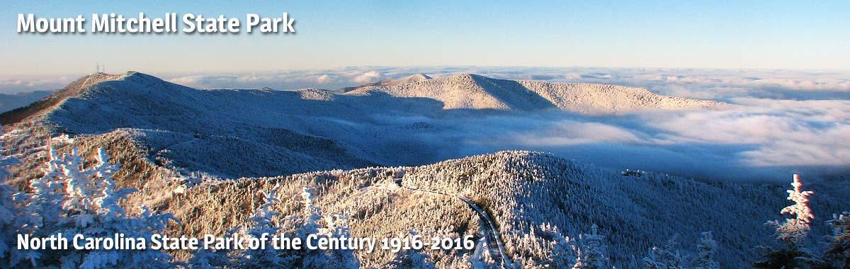 Sweeping panoramic view of snow-covered mountains from Mount Mitchell State Park in winter with text overlay reading North Carolina State Park of the Century 1916-2016