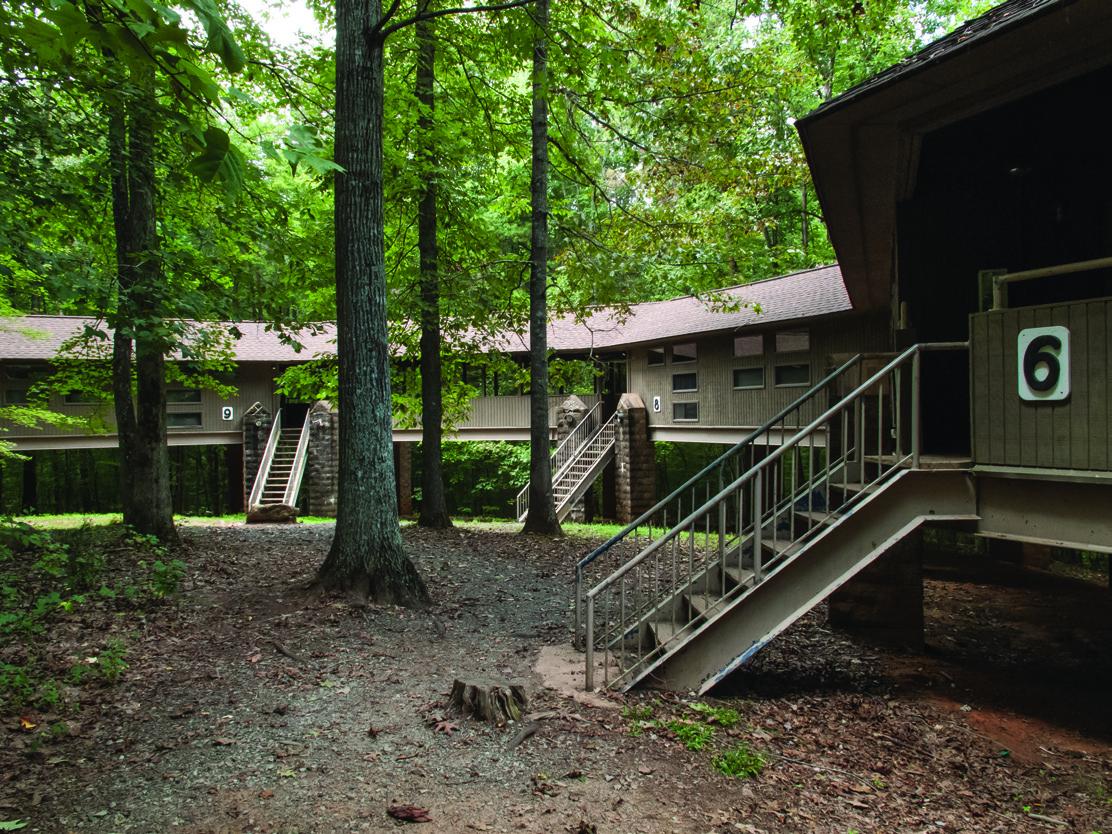 Photo of a youth cabin building exterior nestled in trees at Haw River State Park