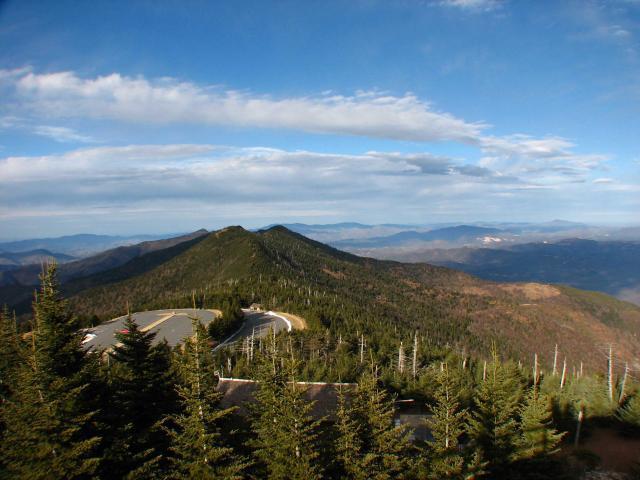 Scenic view of Mount Mitchell peak and surrounding forested mountains under a partly cloudy sky