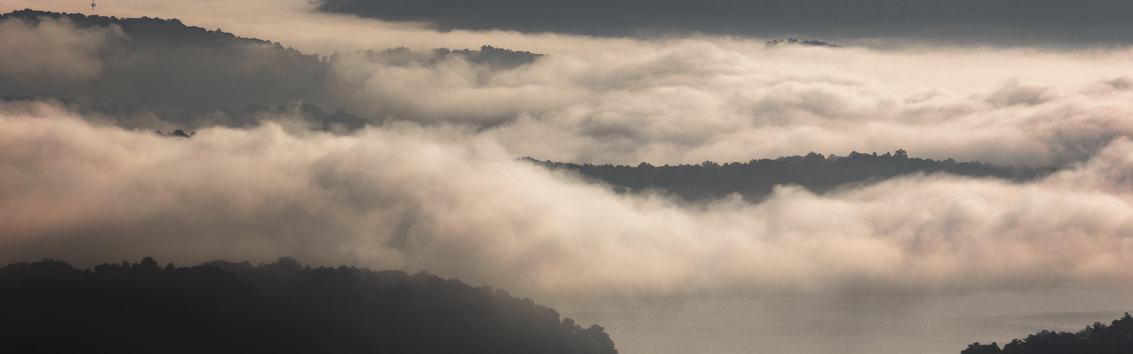 Clouds hover over Lake Lure in the morning, as seen from Chimney Rock State Park