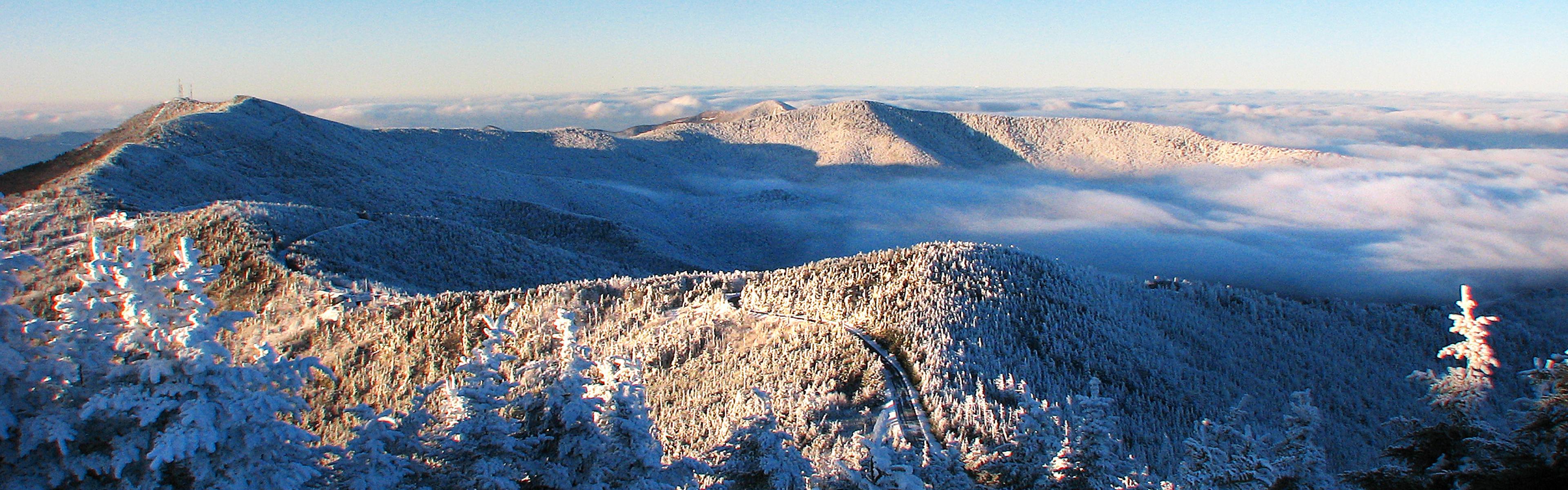 Snow-covered mountains with a cloud inversion and clear sky