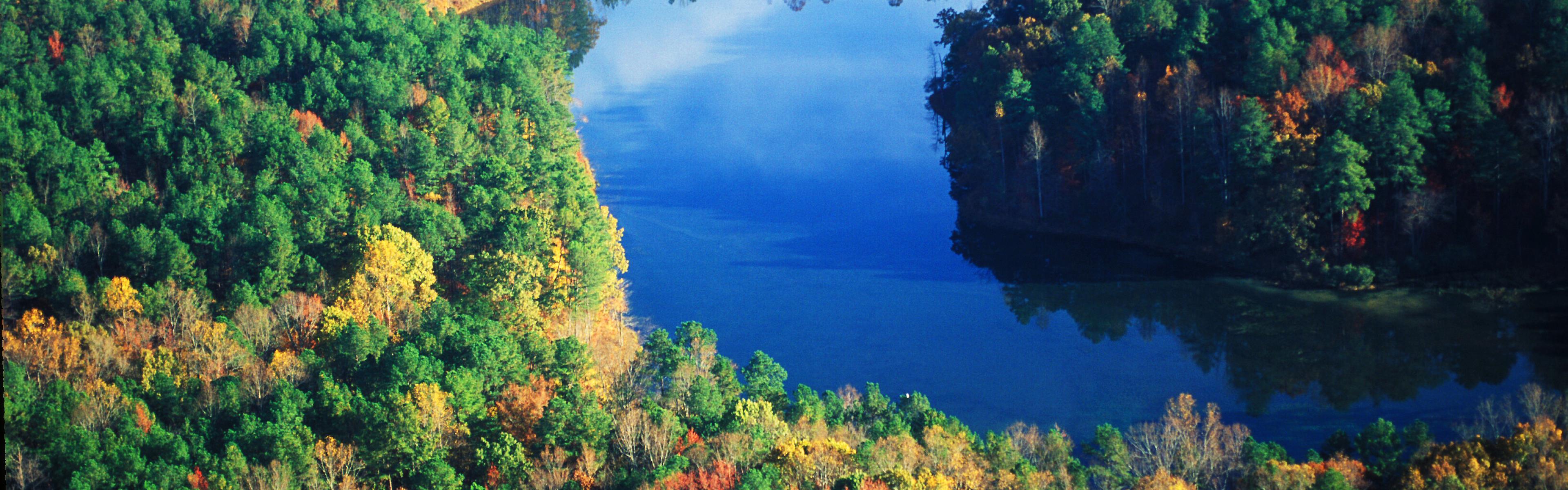 Umstead Park Lake reflects the sky surrounded by early fall colors
