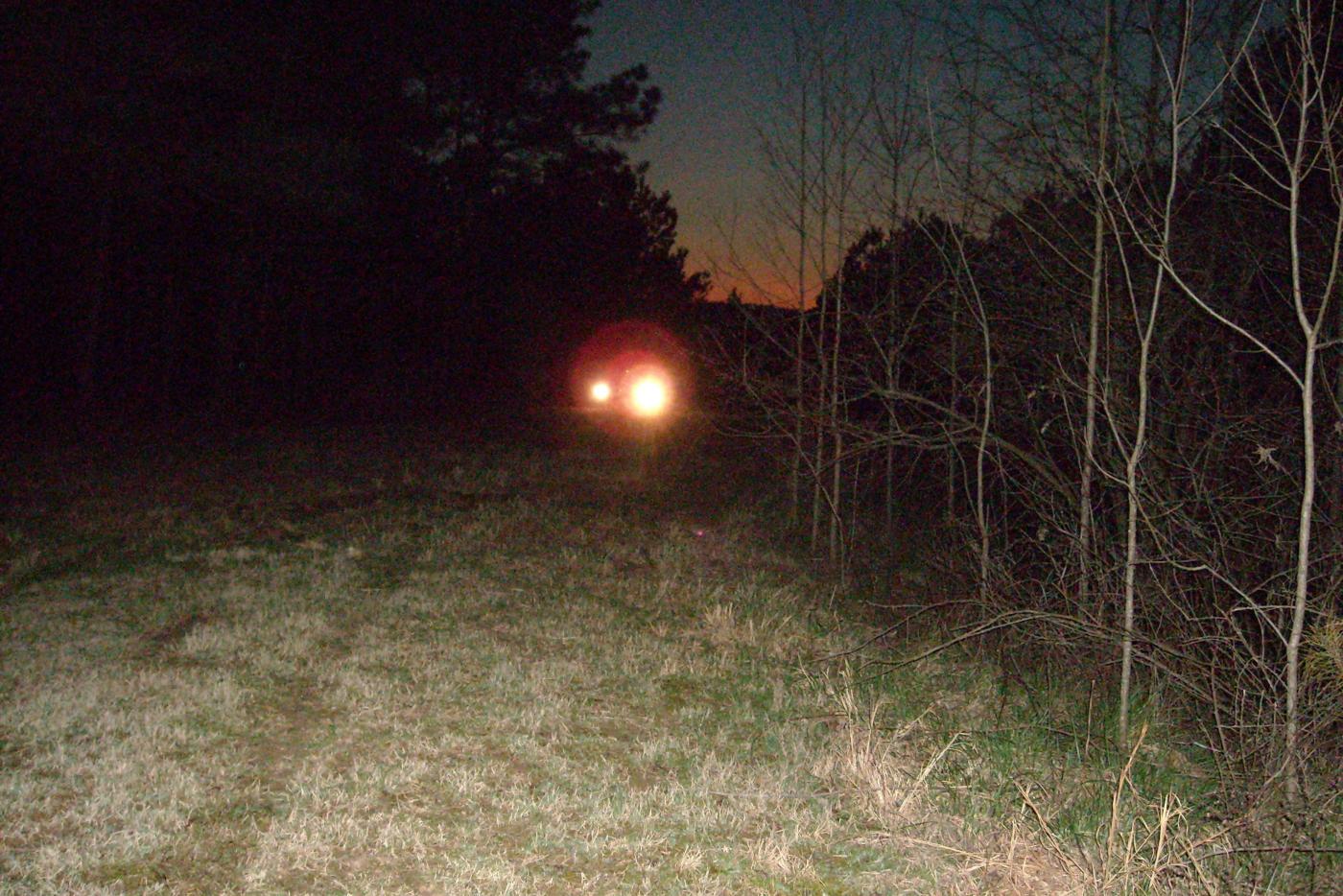 Truck headlights on a dark trail