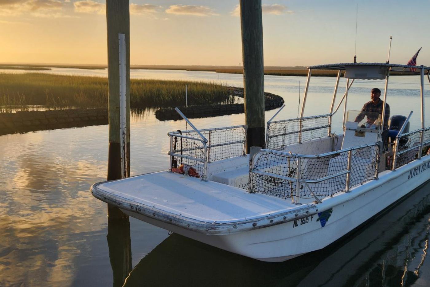 Small ferry boat pulling into the dock at sunset