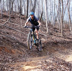 Photo of a mountain biker riding on a wooded trail at Buffalo Creek Park