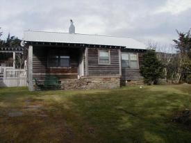 Ranger Residence #1 built in 1950 featuring a rustic cabin-style structure with wood siding nestled against evergreen trees