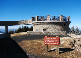 Observation deck at Mount Mitchell with stone walls and informational signs overlooking the mountain range