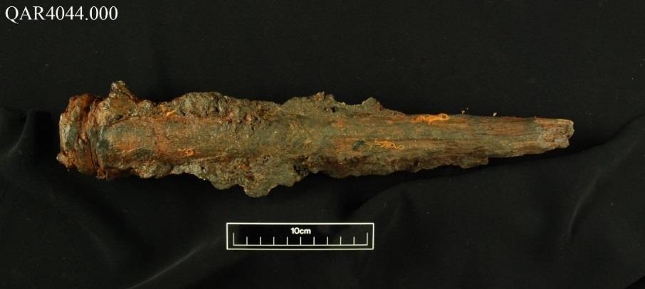 A large, heavily concreted fastener artifact with a 10cm scale bar