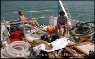 Crew members on the deck of a research vessel adjusting equipment