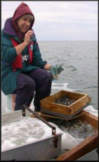 Person on a boat looking at a screen box over a container