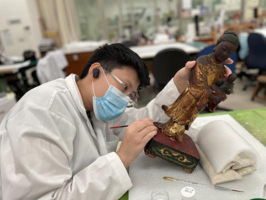 Yu Shih cleaning an artifact