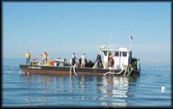 Archaeologists working on a boat deck with a diesel pump