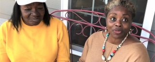 Two women sitting on front porch and talking