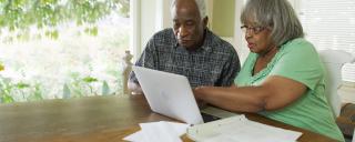 Older African American couple looking at computer