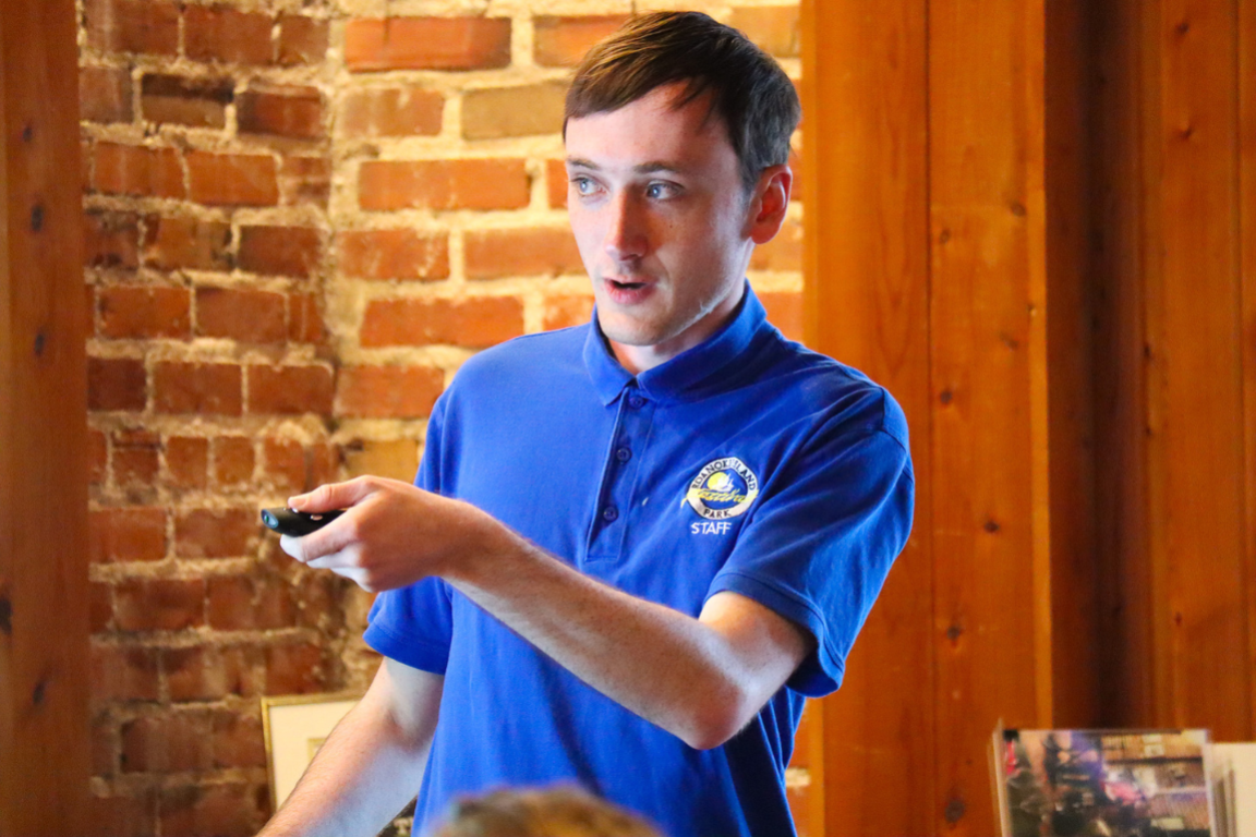 Caleb Hempton, close up of a young man with a remote pointing at a screen.