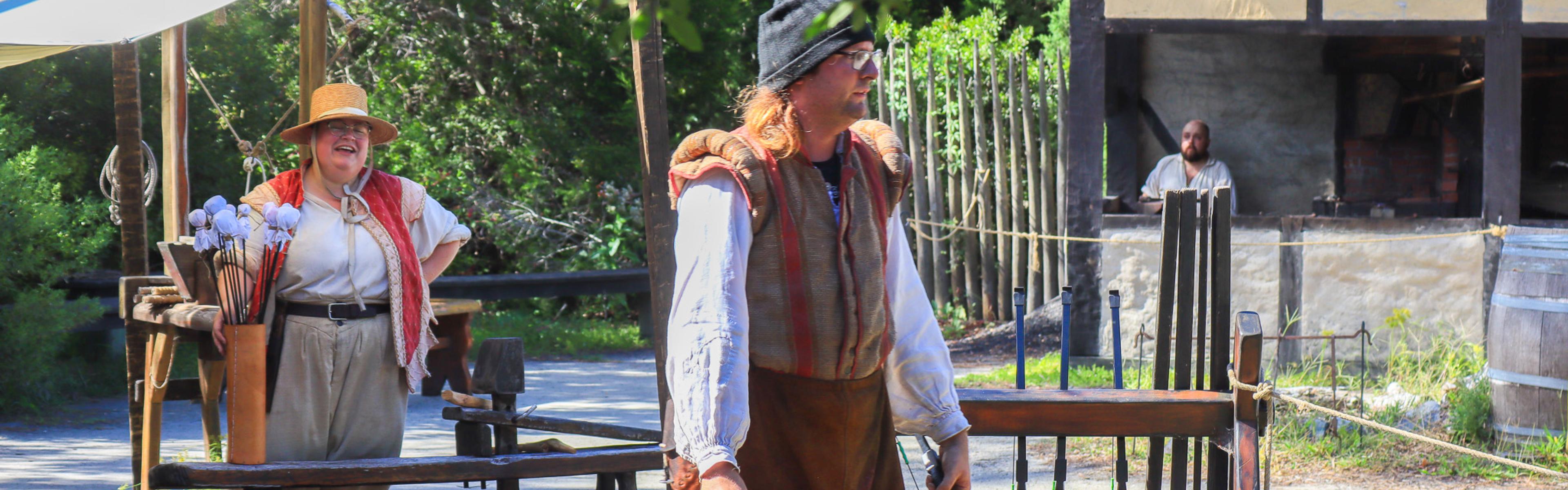 Two costumed interpreters in the Settlement Site 