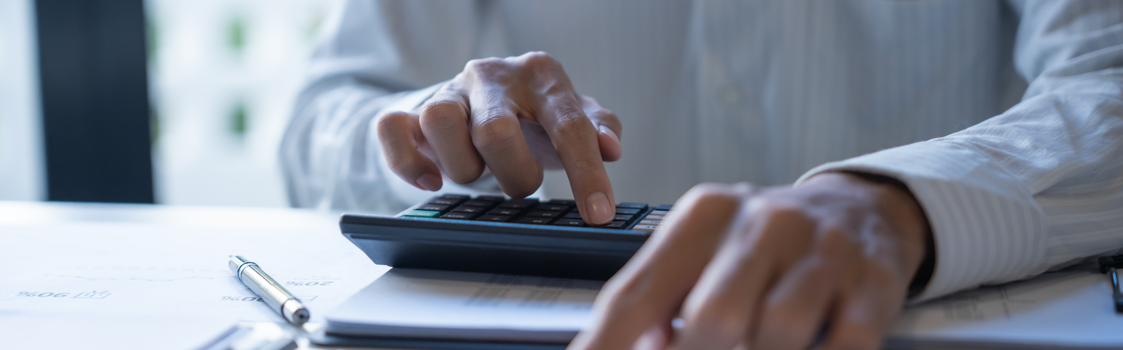 The hands of a treasurer as they use a calculator to monitor campaign contributions and expenditures.